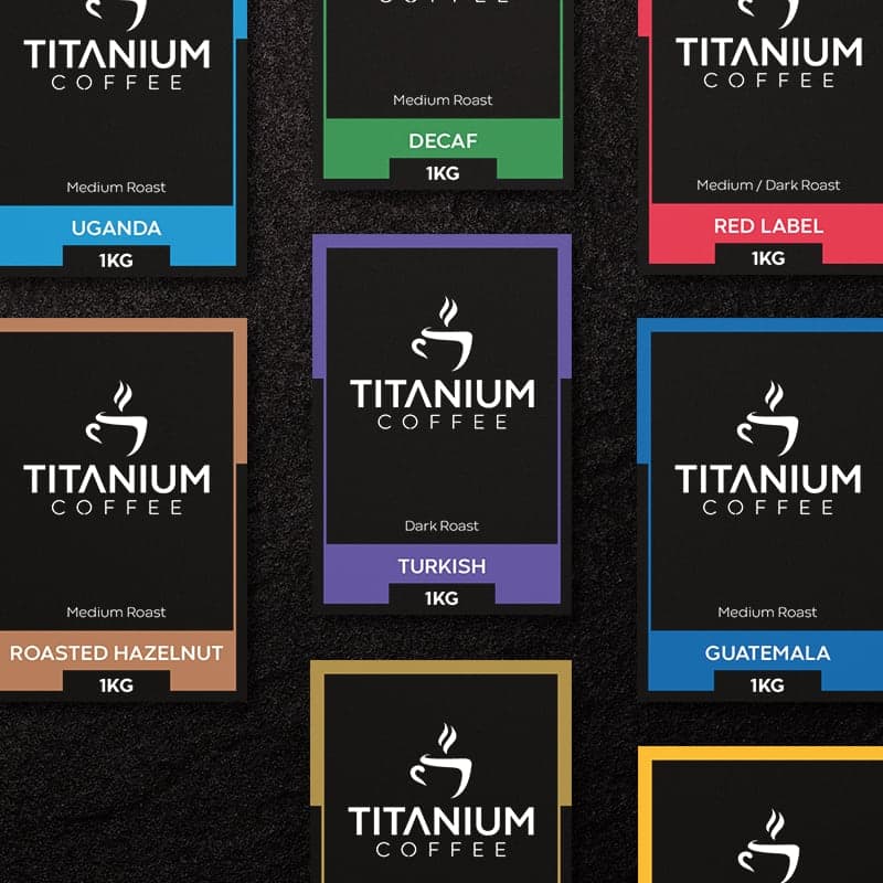 Titanium Coffee colour-coded label system showing full blend range with matte black backgrounds